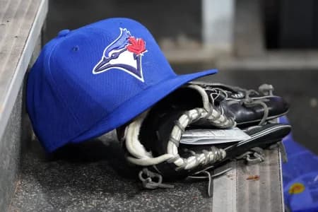 A Toronto Blue Jays hat and glove in the dugout during a game against the Atlanta Braves at Rogers Centre.