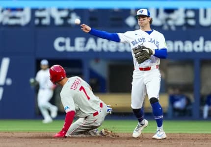 Toronto Blue Jays second baseman Ernie Clement (22) throws to first base against Philadelphia Phillies shortstop Trea Turner (7) during the third inning at Rogers Centre.