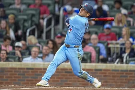 Toronto Blue Jays center fielder Daulton Varsho (5) hits a sacrifice fly ball to drive in a run against the Atlanta Braves during the sixth inning at Truist Park.