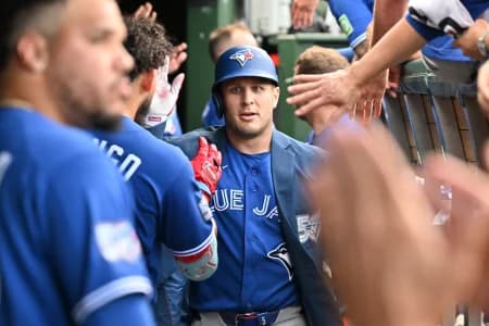 Toronto Blue Jays center fielder Daulton Varsho (5) celebrates with teammates in the dugout after hitting a three-run home run against the Chicago Cubs during the seventh inning at Wrigley Field.