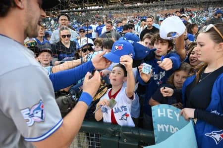 Toronto Blue Jays fans clamor for an autograph from Toronto Blue Jays second baseman Ernie Clement (22) before their game against the Detroit Tigers at Comerica Park.