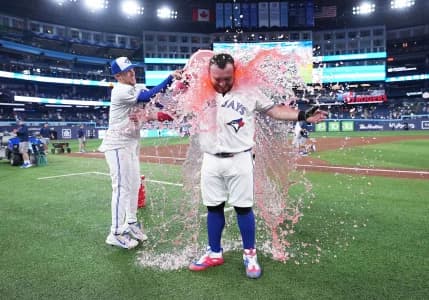 Toronto Blue Jays catcher Alejandro Kirk (30) has the water bucket poured on him against the Houston Astros at the end of the ninth inning at Rogers Centre.