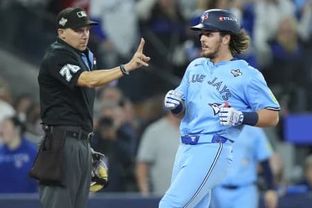 Home plate umpire Adam Hamari (78) signals to Toronto Blue Jays right fielder Addison Barger (47) that he is only allowed two bases on a ground rule double as he crosses home plate against the Los Angeles Dodgers during the ninth inning of game six of the 2025 MLB World Series at Rogers Centre.