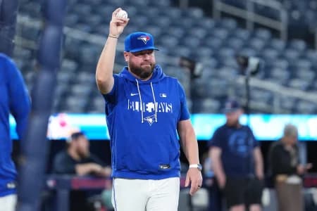 Toronto Blue Jays manager John Schneider (14) walks onto the field during batting practice before a game against the Cleveland Guardians at Rogers Centre.