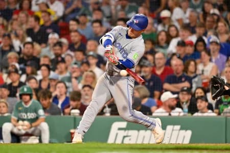 Toronto Blue Jays center fielder Daulton Varsho (5) hits a single against the Boston Red Sox during the fourth inning at Fenway Park.