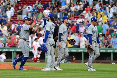 Toronto Blue Jays pitcher Dylan Cease (84) high fives his teammates after defeating the Boston Red Sox at Fenway Park.