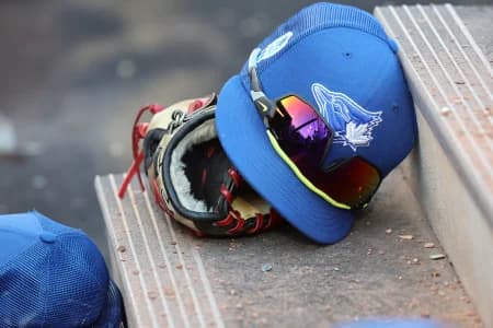 A detail view of Toronto Blue Jays hat and glove against the Detroit Tigers at TD Ballpark