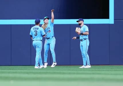 Toronto Blue Jays left fielder Myles Straw (3) and center fielder Brett Bateman (21) and right fielder Nathan Lukes (38) celebrate the win gainst the New York Yankees at the end of the ninth inning at Rogers Centre.