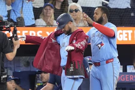 Toronto Blue Jays first baseman Vladimir Guerrero Jr. (27) puts the home run jacket onto right fielder Nathan Lukes (38) after his three run home run against the Kansas City Royals during the fourth inning at Rogers Centre.
