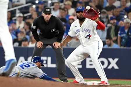 Toronto Blue Jays first baseman Vladimir Guerrero Jr. (27) catches a pickoff throw as Kansas City Royals third baseman Nick Loftin (12) dives back to first base in the sixth inning at Rogers Centre.