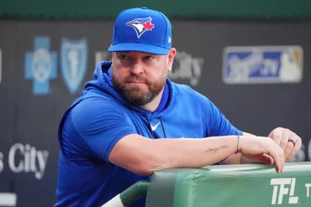 Toronto Blue Jays manager John Schneider (14) looks out from the dugout against the Kansas City Royals prior to a game at Kauffman Stadium