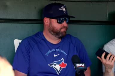 Toronto Blue Jays manager John Schneider (14) speaks to the media in the dugout before a game against the Athletics at Sutter Health Park.