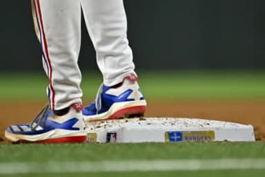 A view the shoes of Texas Rangers right fielder Evan Carter (32) and first base and the Rangers World Champions logo during the game against the Chicago Cubs at Globe Life Field