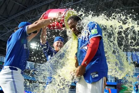 Toronto Blue Jays infielder Josh Smith (left) and center fielder Myles Straw (3) douse first baseman Vladimir Guerrero Jr. (27) with a sport drink after a win over the Baltimore Orioles at Rogers Centre.