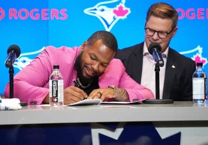 Toronto Blue Jays first baseman Vladimir Guerrero Jr. signs the contract with general manager Ross Atkins during the Toronto Blue Jays press conference at Rogers Centre.
