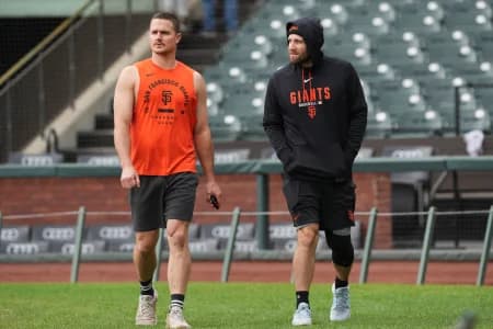 San Francisco Giants third baseman Matt Chapman (left) and second baseman Casey Schmitt (right) walk on the field before the game against the Colorado Rockies at Oracle Park.