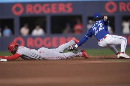 Toronto Blue Jays second baseman Ernie Clement (22) catches Cincinnati Reds right fielder Hector Rodriguez (43) trying to steal second base during the second inning at Rogers Centre.