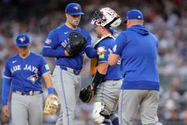 Toronto Blue Jays starting pitcher Mason Fluharty (68) hands the ball to Toronto Blue Jays manager John Schneider (14) during a pitching change during the first inning against the New York Yankees at Yankee Stadium