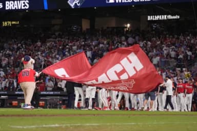 Atlanta Braves mascot Blooper waves a flag to celebrate after the Atlanta Braves defeated the Philadelphia Phillies in game three of the Wildcard round for the 2026 MLB Playoffs at Truist Field.