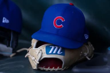 A detailed view of a Chicago Cubs hat and glove in the dugout before a game against the Atlanta Braves at Truist Park.