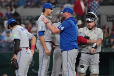 Toronto Blue Jays manager John Schneider (14) places his hands on the shoulders of pitcher Jose Rodriguez (64) prior to pitching in his major league debut against the Texas Rangers during the sixth inning at Globe Life Field