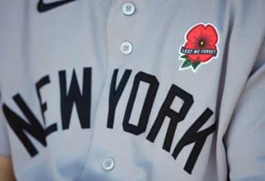 A detailed view of the a red poppy flower patch on the jersey worn by New York Yankees left fielder Cody Bellinger (35) in honor of Memorial Day prior to a game against the Kansas City Royals at Kauffman Stadium.