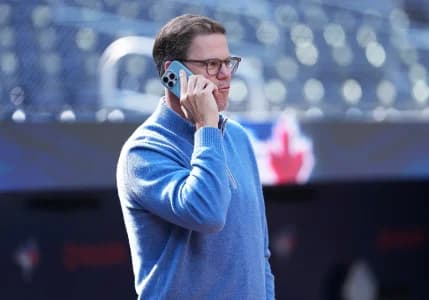 Toronto Blue Jays general manager Ross Atkins talks on the phone during batting practice before a game against the Baltimore Orioles at Rogers Centre.
