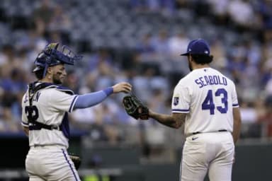 Kansas City Royals catcher Carter Jensen (22) hands the ball to Kansas City Royals pitcher Connor Seabold (43) during the fifth inning against the Tampa Bay Rays at Kauffman Stadium.