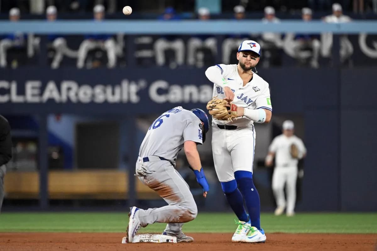 Los Angeles Dodgers catcher Will Smith (16) is out at second base as Toronto Blue Jays second baseman Bo Bichette (11) attempts to turn a double play in the second inning during game one of the 2025 MLB World Series at Rogers Centre.