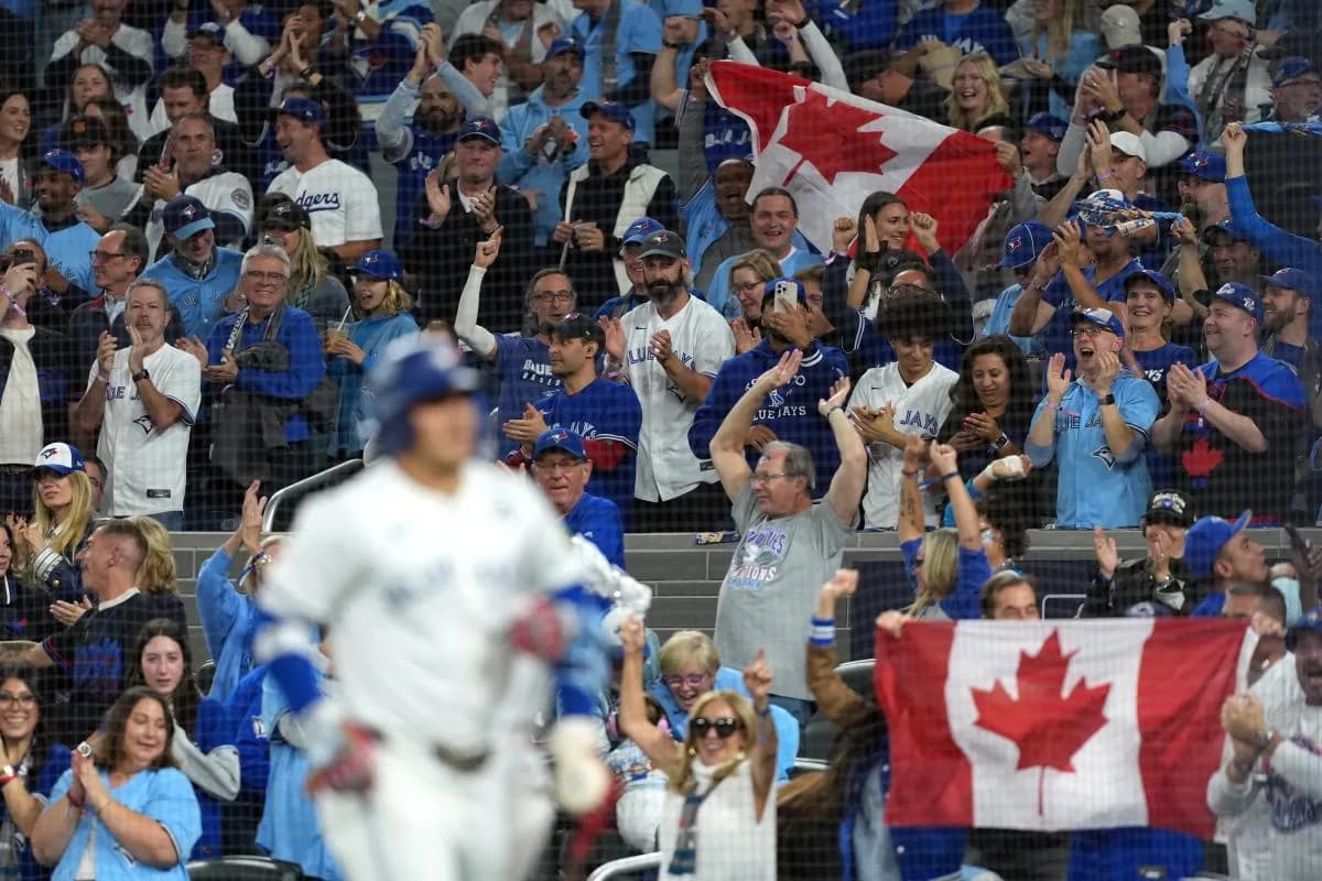 Fans celebrate after a two run home run by Toronto Blue Jays center fielder Daulton Varsho (5) in the fourth inning against the Los Angeles Dodgers during game one of the 2025 MLB World Series at Rogers Centre.