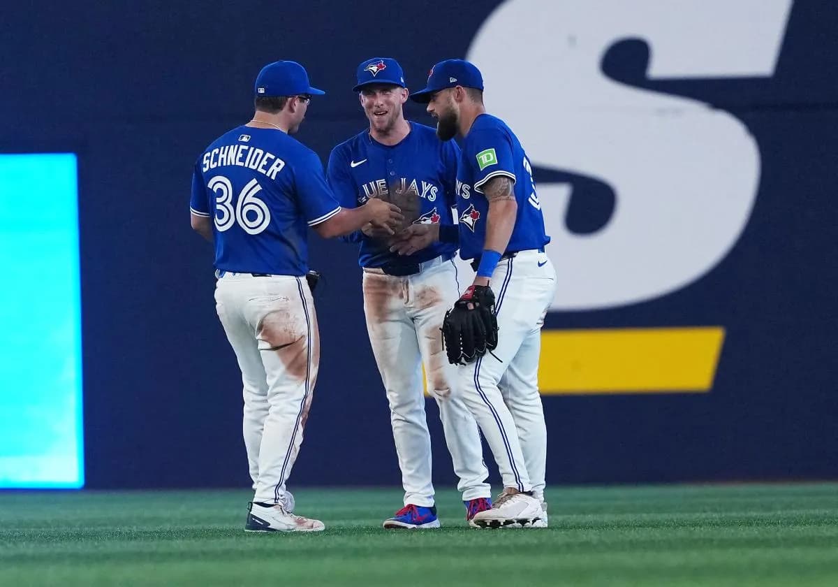 Toronto Blue Jays left fielder Davis Schneider (36) and centre fielder Myles Straw (3) and right fielder Nathan Lukes (38) celebrate the win against the New York Yankees at the end of the ninth inning at Rogers Centre.