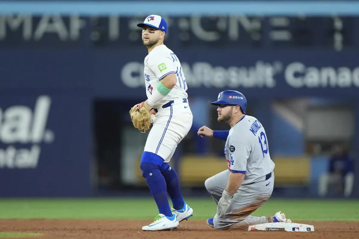 Los Angeles Dodgers third baseman Max Muncy (13) is out against Toronto Blue Jays designated hitter Bo Bichette (11) in the sixth inning during game seven of the 2025 MLB World Series at Rogers Centre.