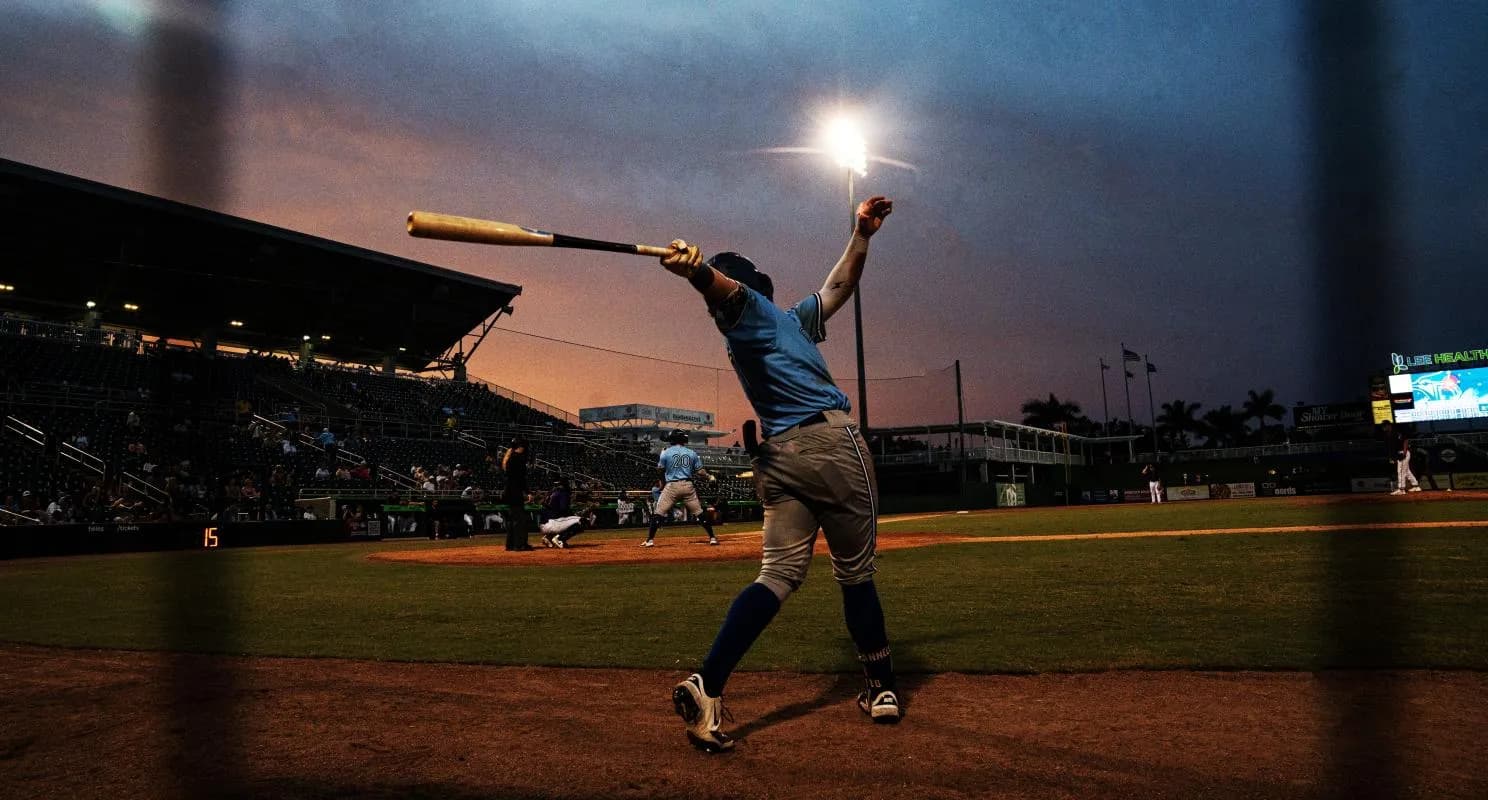 As the sun sets behind the stadium, Matt Scannell, a player for the Dunedin Blue Jays warms up in the batters box during a games against the Fort Myers Might Mussels at Hammond Stadium on Saturday, Aug. 2, 2025. The Mussels won 3-2 in extra innings.