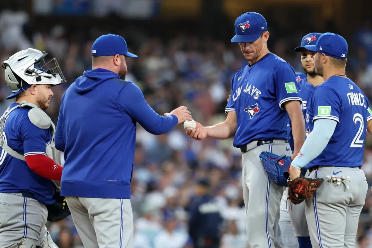 Toronto Blue Jays starting pitcher Chris Bassitt (40) hands a ball to manager John Schneider (14) during the fifth inning against the Los Angeles Dodgers at Dodger Stadium.