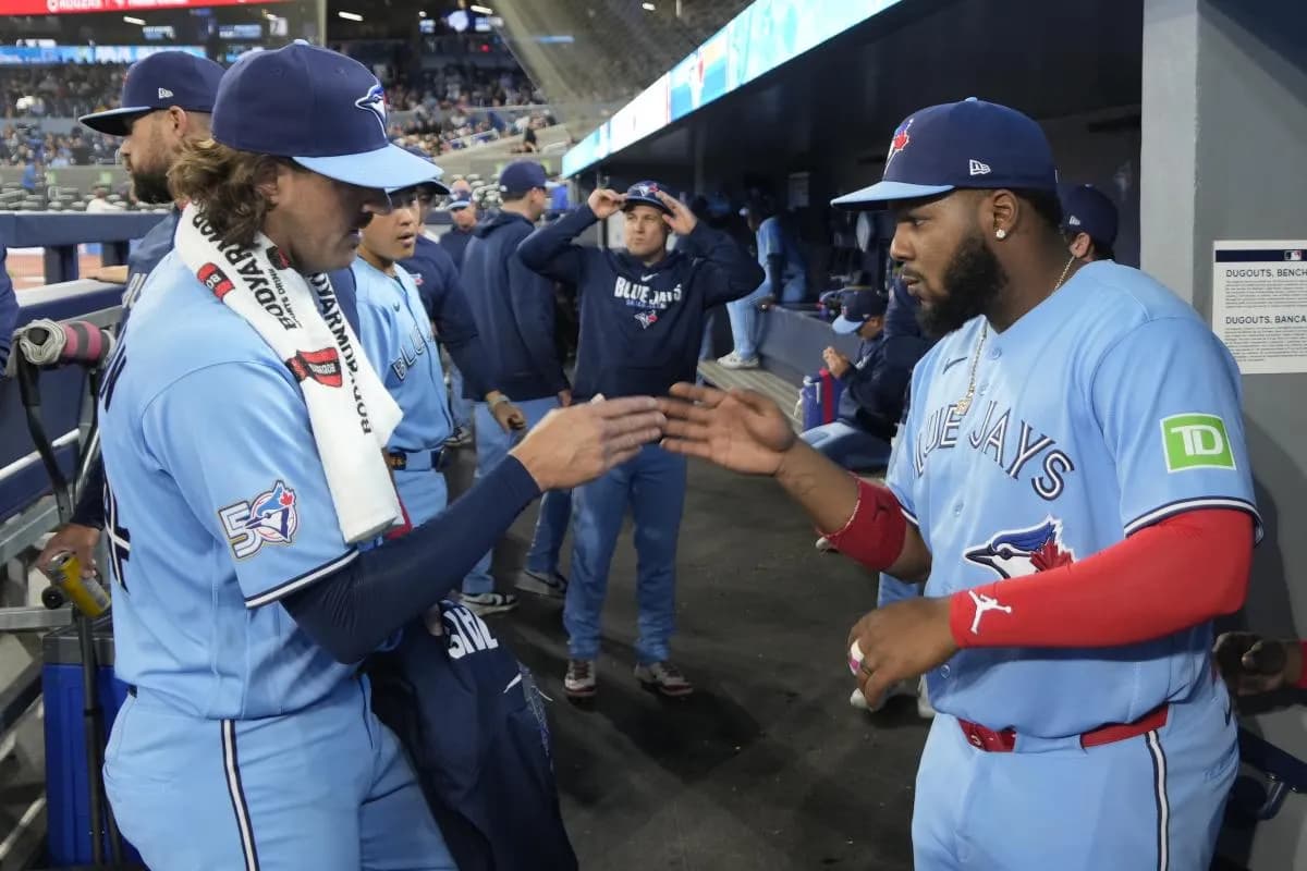 Toronto Blue Jays starting pitcher Kevin Gausman (34) and first baseman Vladimir Guerrero Jr. (27) shake hans before the start of the game against the Colorado Rockies at Rogers Centre.
