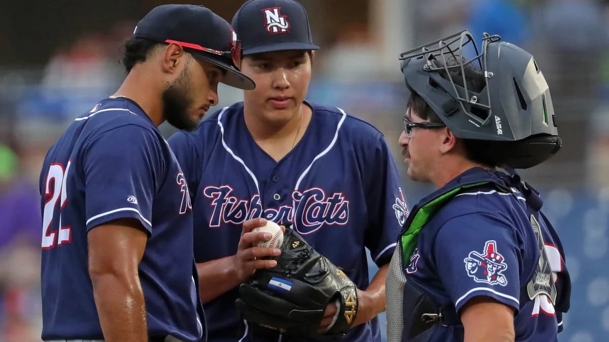 New Hampshire Fisher Cats starting pitcher Fernando Perez, center, has a meeting at the mound with shortstop Alex De Jesus, left, and catcher Robert Brooks during the second inning of a Minor League Baseball game at Canal Park, Aug. 21, 2025, in Akron, Ohio.