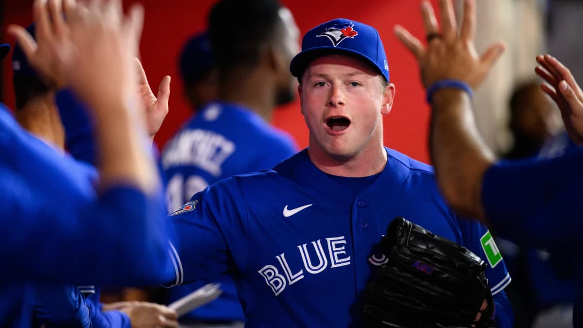 Toronto Blue Jays pitcher Louis Varland (77) is greeted by teammates after a pitching change during the eighth inning against the Los Angeles Angels at Angel Stadium.