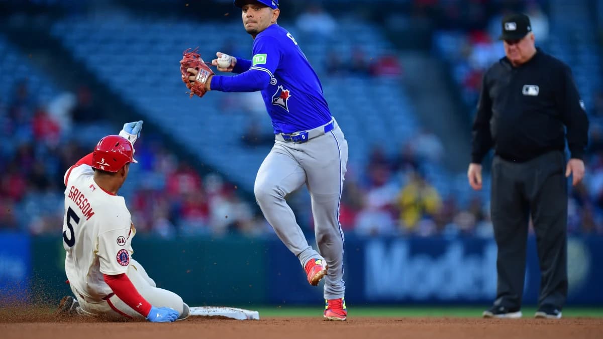 Los Angeles Angels second baseman Vaughn Grissom (5) is out at second as Toronto Blue Jays shortstop Andres Gimenez (0) throws to first for the out against catcher Logan O'Hoppe (14) during the third inning at Angel Stadium.