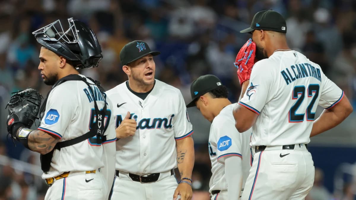Miami Marlins pitching coach Daniel Moskos (57) speaks to starting pitcher Sandy Alcantara (22) during a mound visit against the Colorado Rockies in the fourth inning at loanDepot Park.