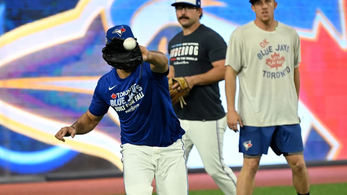 Toronto Blue Jays outfielders Myles Straw (3) and Davis Schneider (36) watch outfielder Anthony Santander (25) make a catch during workouts for the American League Championship Series at Rogers Centre.