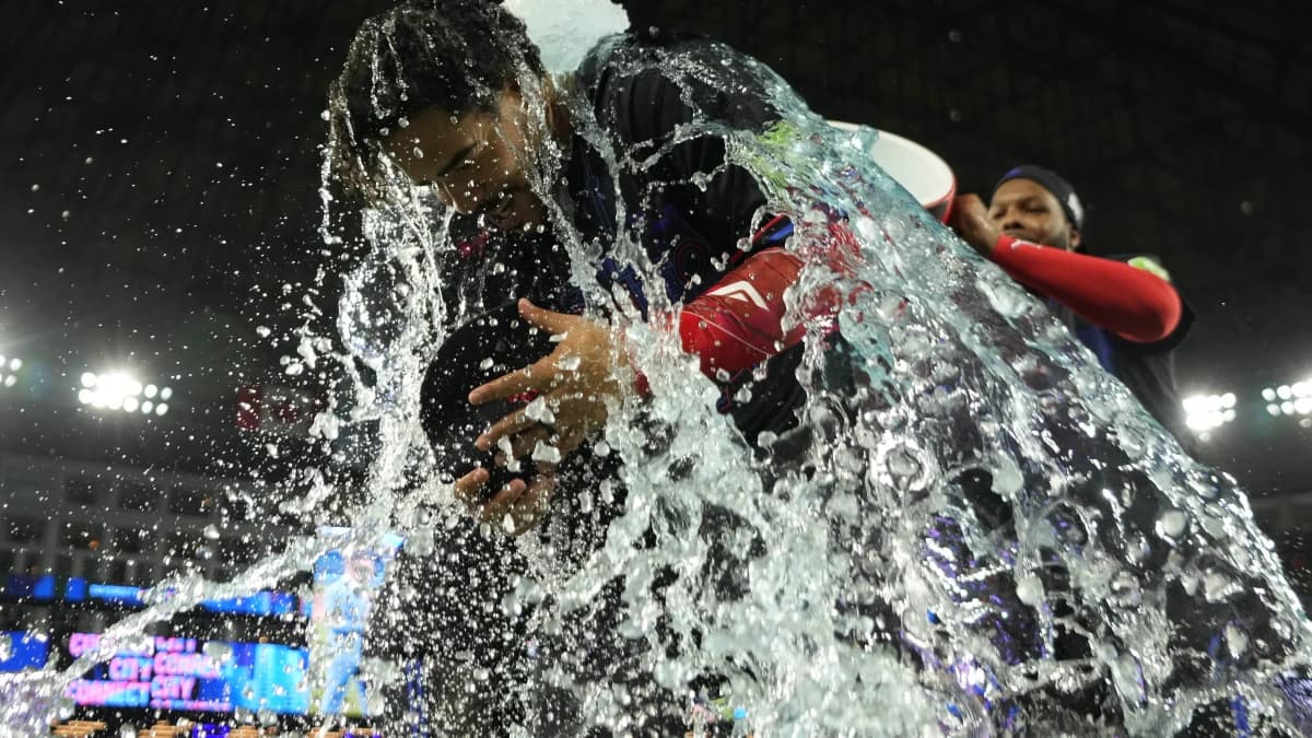 Toronto Blue Jays left fielder Yohendrick Pinango (24) gets doused with ice water by Toronto Blue Jays first baseman Vladimir Guerrero Jr. (27) after a win against the Pittsburgh Pirates at Rogers Centre.