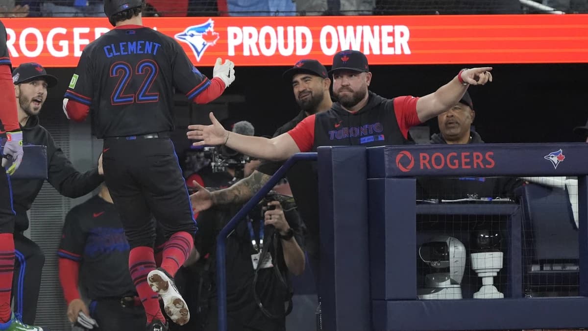 Toronto Blue Jays manager John Schneider congratulates second baseman Ernie Clement (22) after he scores against the Pittsburgh Pirates during the eighth inning at Rogers Centre