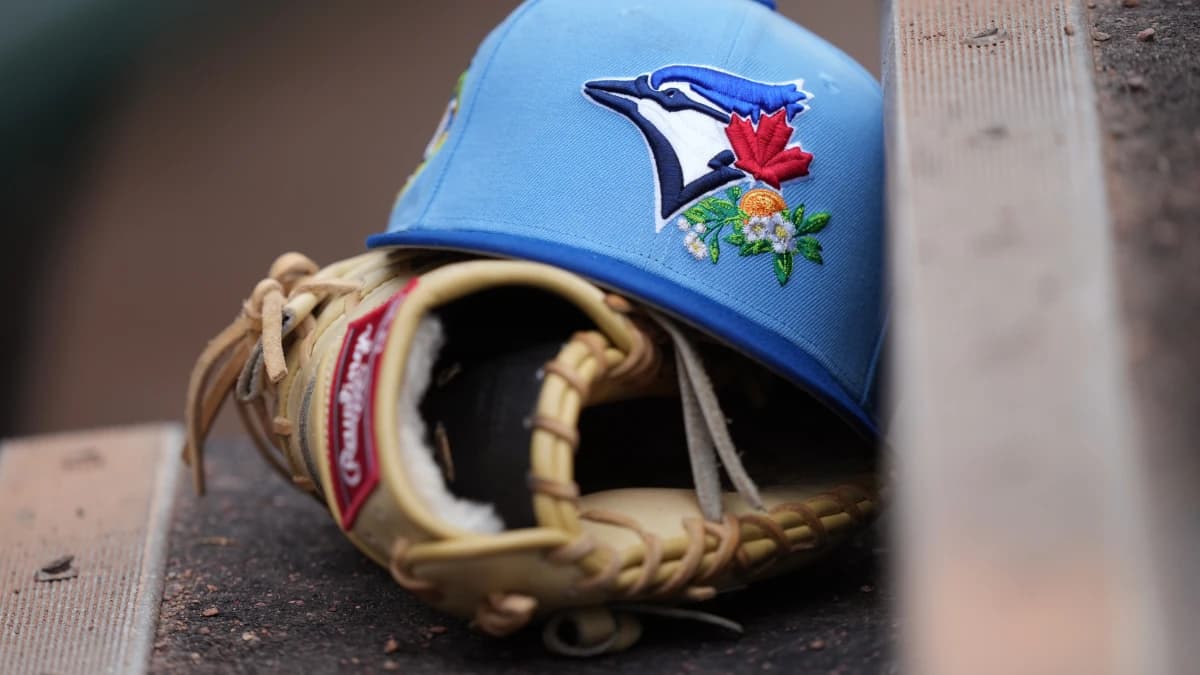 Detail photo. A Toronto Blue Jays hat and glove rest on the first base dugout steps at Roger Dean Chevrolet Stadium before the game against the Miami Marlins .
