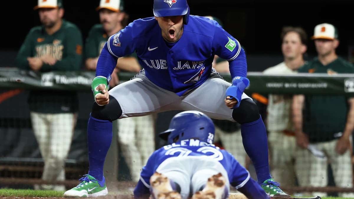Toronto Blue Jays designated hitter George Springer (4) celebrates as Toronto Blue Jays shortstop Ernie Clement (22) slides home to score a run during the eighth inning against the Baltimore Orioles at Oriole Park at Camden Yards.