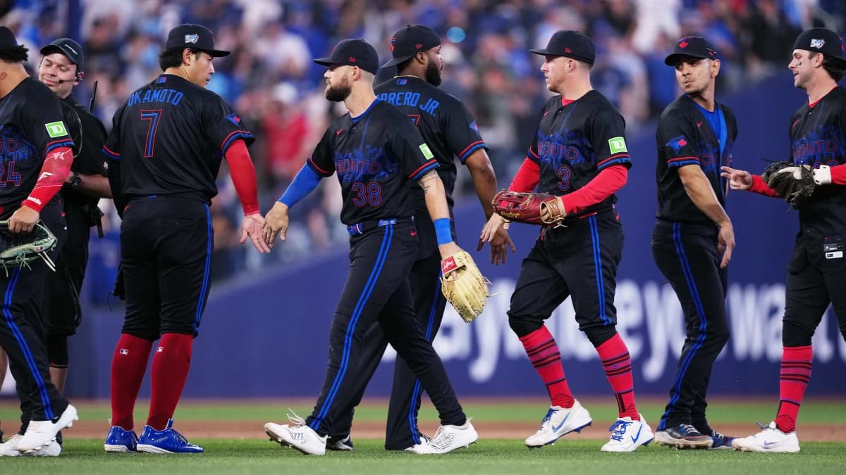 Toronto Blue Jays third baseman Kazuma Okamoto (7) celebrates the win with right fielder Nathan Lukes (38) against the New York Yankees at the end of the ninth inning at Rogers Centre.