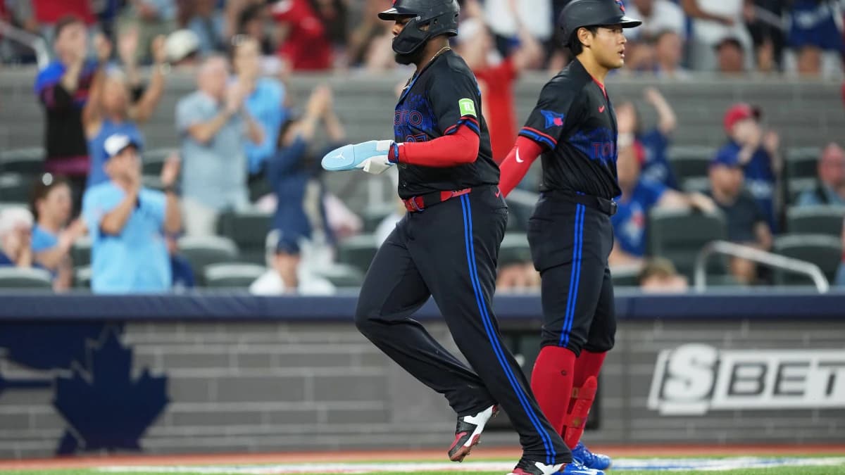 Toronto Blue Jays first baseman Vladimir Guerrero Jr. (27) scores a run and celebrates with third baseman Kazuma Okamoto (7) against the New York Yankees during the fifth inning at Rogers Centre.