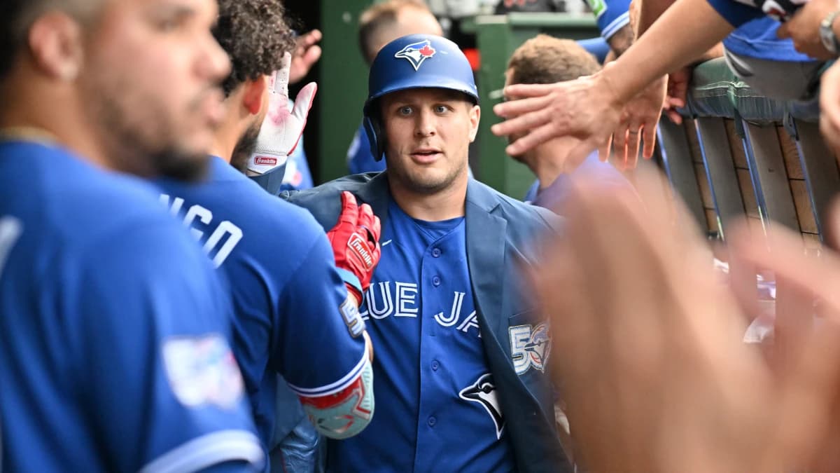 Toronto Blue Jays center fielder Daulton Varsho (5) celebrates with teammates in the dugout after hitting a three-run home run against the Chicago Cubs during the seventh inning at Wrigley Field.