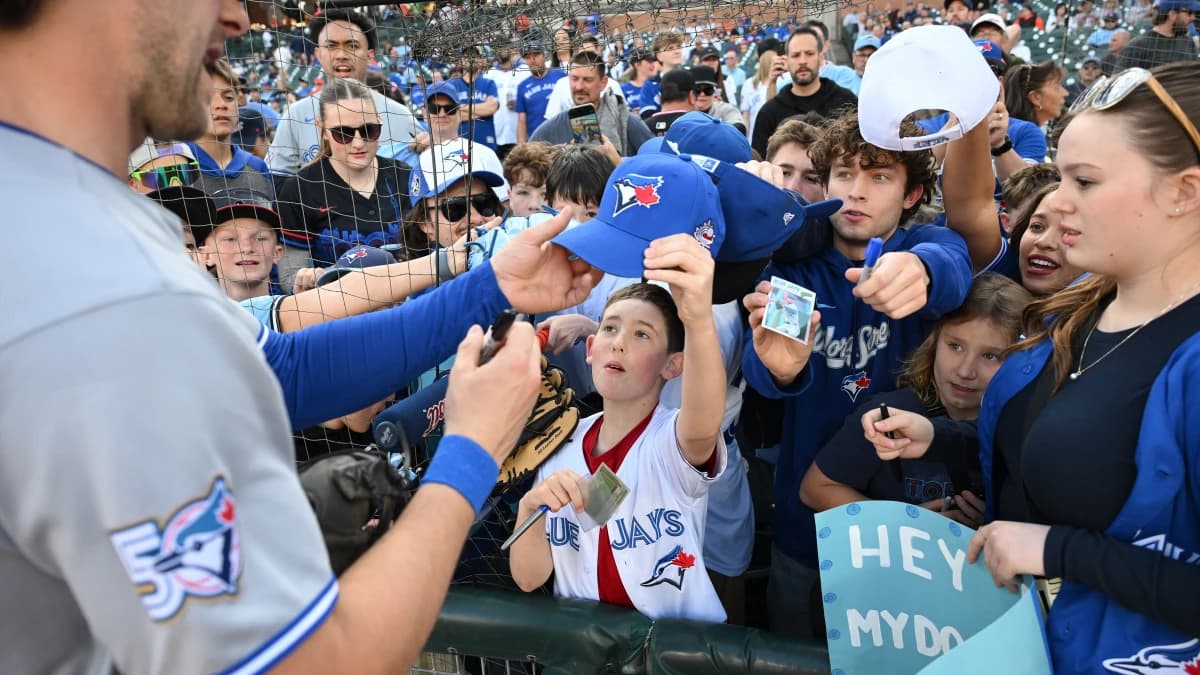 Toronto Blue Jays fans clamor for an autograph from Toronto Blue Jays second baseman Ernie Clement (22) before their game against the Detroit Tigers at Comerica Park.