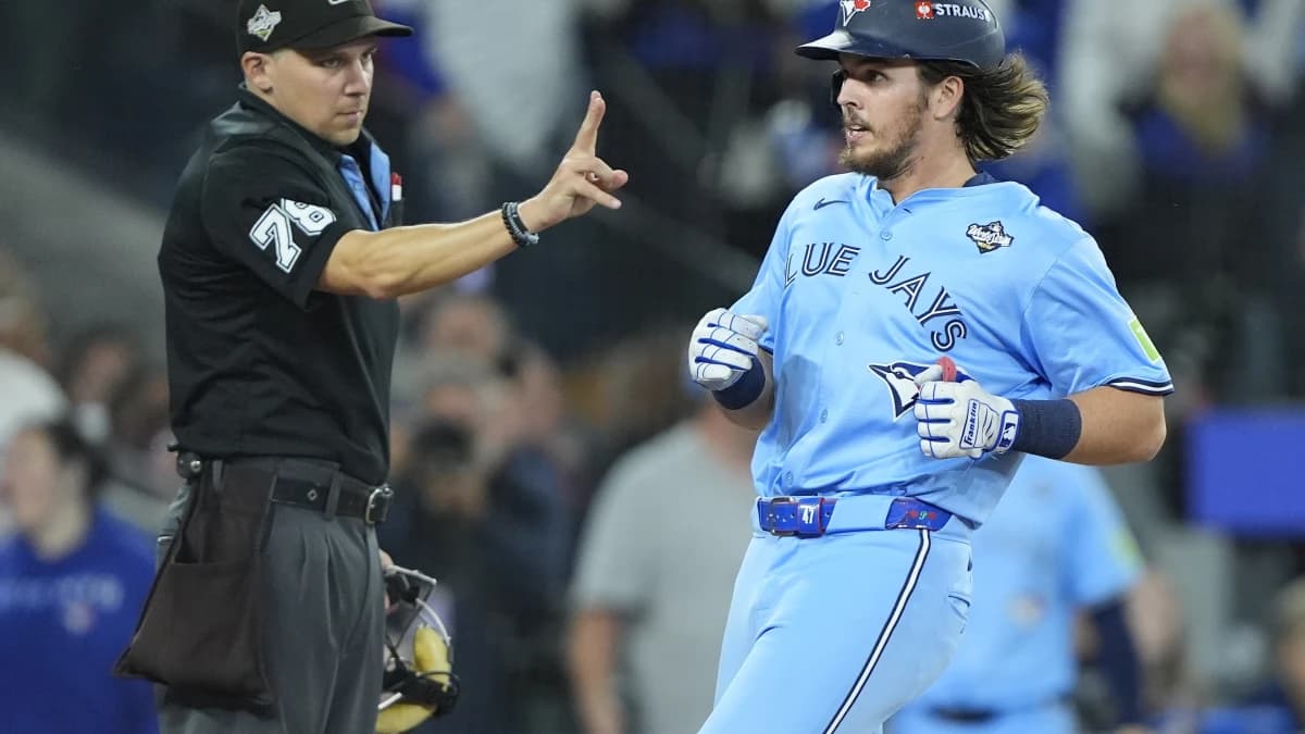 Home plate umpire Adam Hamari (78) signals to Toronto Blue Jays right fielder Addison Barger (47) that he is only allowed two bases on a ground rule double as he crosses home plate against the Los Angeles Dodgers during the ninth inning of game six of the 2025 MLB World Series at Rogers Centre.