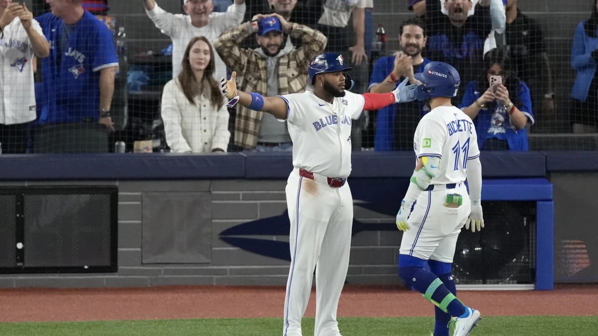 Toronto Blue Jays designated hitter Bo Bichette (11) celebrates with first baseman Vladimir Guerrero Jr. (27) after hitting a three run home run against the Los Angeles Dodgers in the third inning during game seven of the 2025 MLB World Series at Rogers Centre